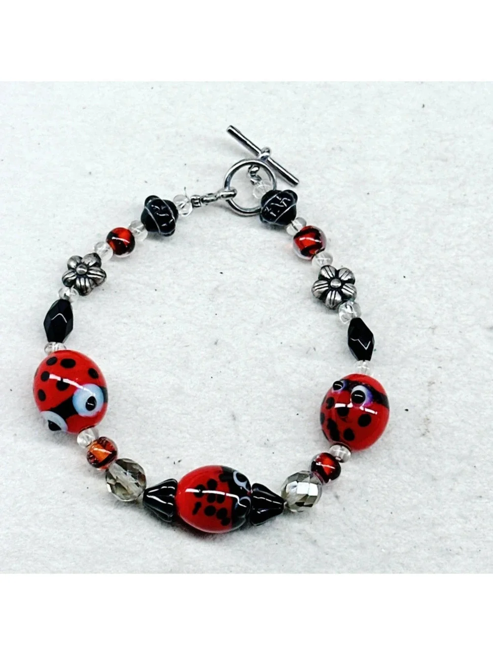 3011u. Silly Ladybug Glass Bracelet Silvertone